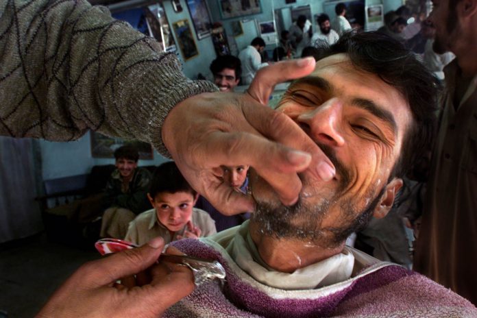 At a barber shop in Kabul, Jawaid, age 23 gladly has his beard shaved off after the restriction of t